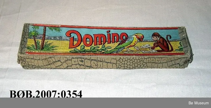 Motiv på loket: Papegøye og apekatt som spelar domino.