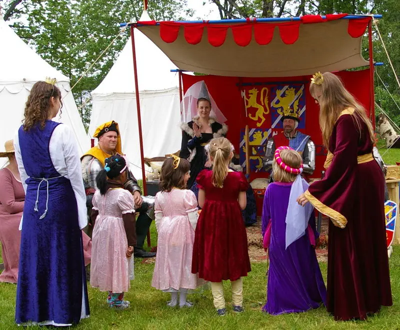 Små prinsesser i fine kjoler møter kongen i rustning og dronningen i houppeland kjole