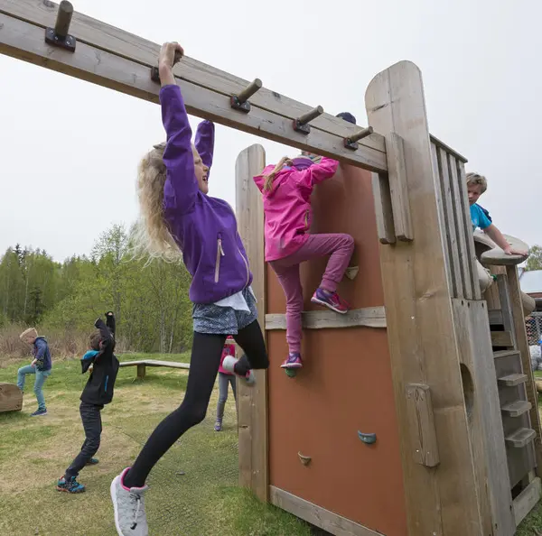 Barn som klatrer i klatrestativ