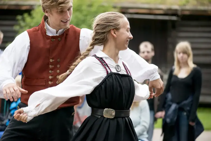 Man and woman folkdansing wearing folk dress
