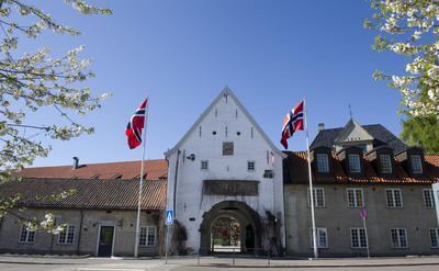 Hovedinngangen til Norsk Folkemuseum med to heiste flagg. Foto/Photo