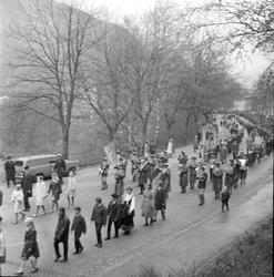 Tog med korps og faner ved kirkesvingen.