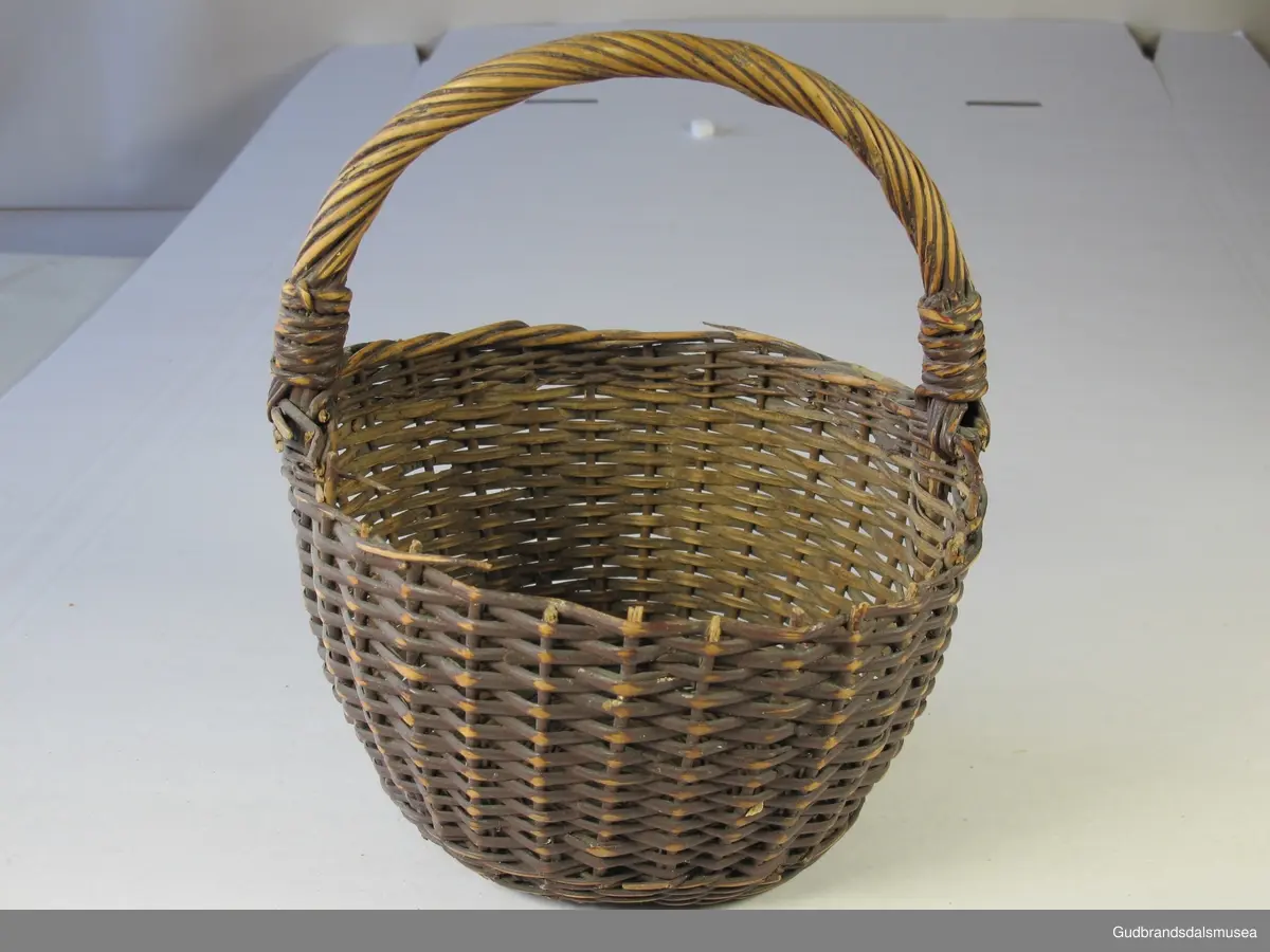 Liten kurv med hank. Sidene er flettet i kløvd kvist, bunnen i rund kvist (pil eller vier).