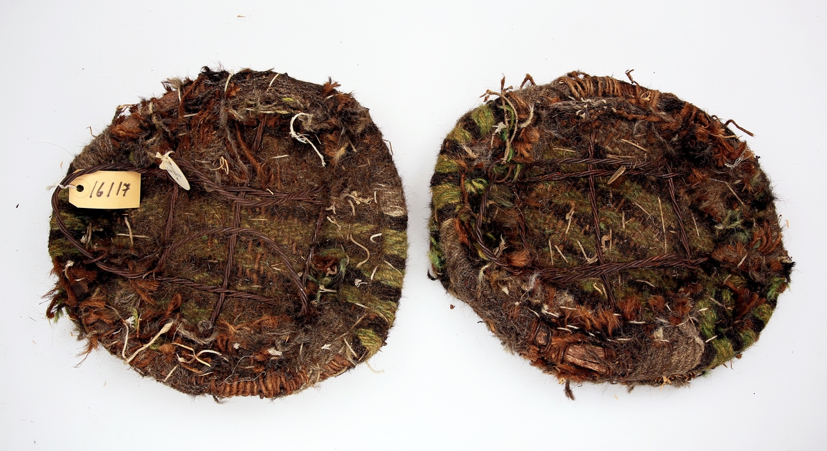 Et par truger med grovstrikket stoff av grovfibret garn og foret med halm. Fotbøylene er av ståltråd