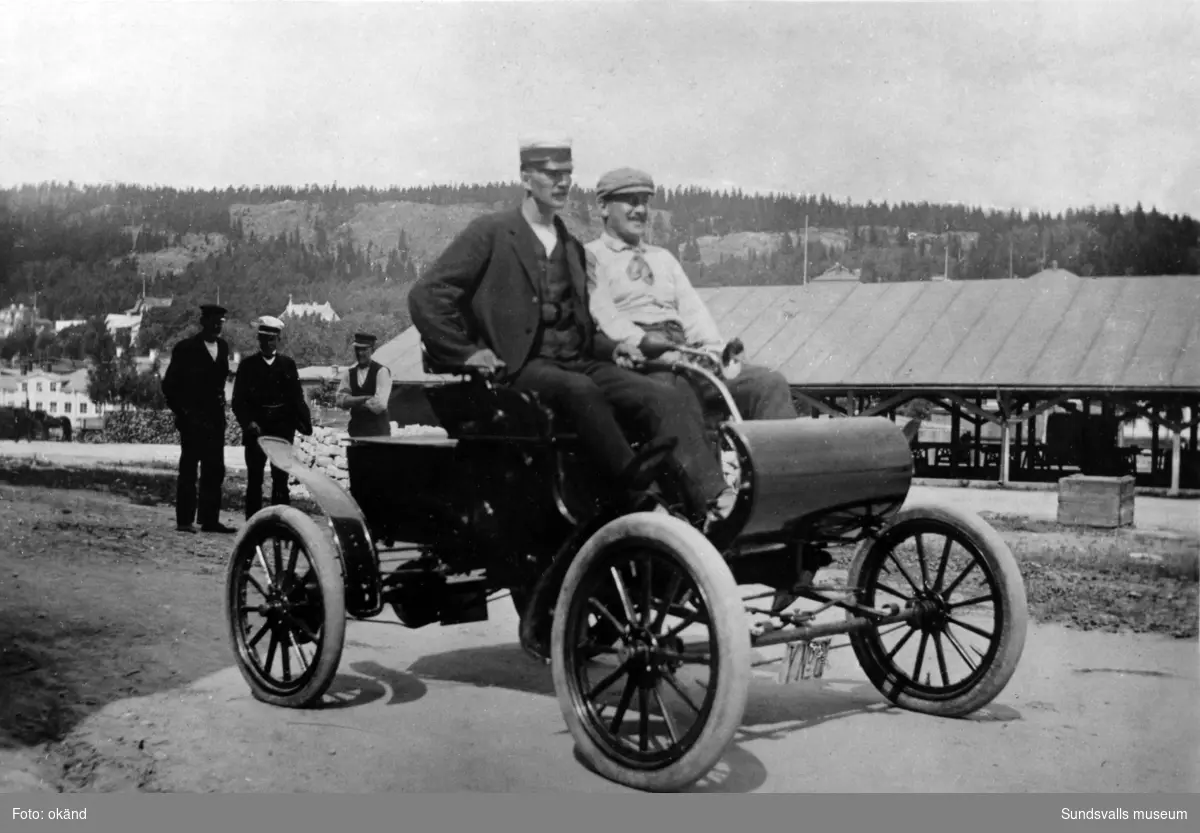Direktör Zadig Hirschfeldt med Sundsvalls första autoobil som användes för affärsresor i karamellfabrikens tjänst ända upp till Haparanda. Chaufför var Herman Höglund (närmast kameran) sedermera föreståndare för Norrköpingslithografens tryckeri i Sundsvall.