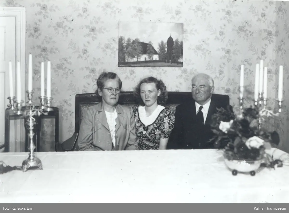 Från höger: Erik Neilertz, född 1894-12-06 död 1961-04-25 dottern Ingegerd, född 1927-06-26 gift Dunge, Snarås, samt Karin Neilertz, född Nilsson 1899-05-19 död 1977-01-26.
Tavlan på väggen är Norra Sandsjö utanför Vetlanda.
