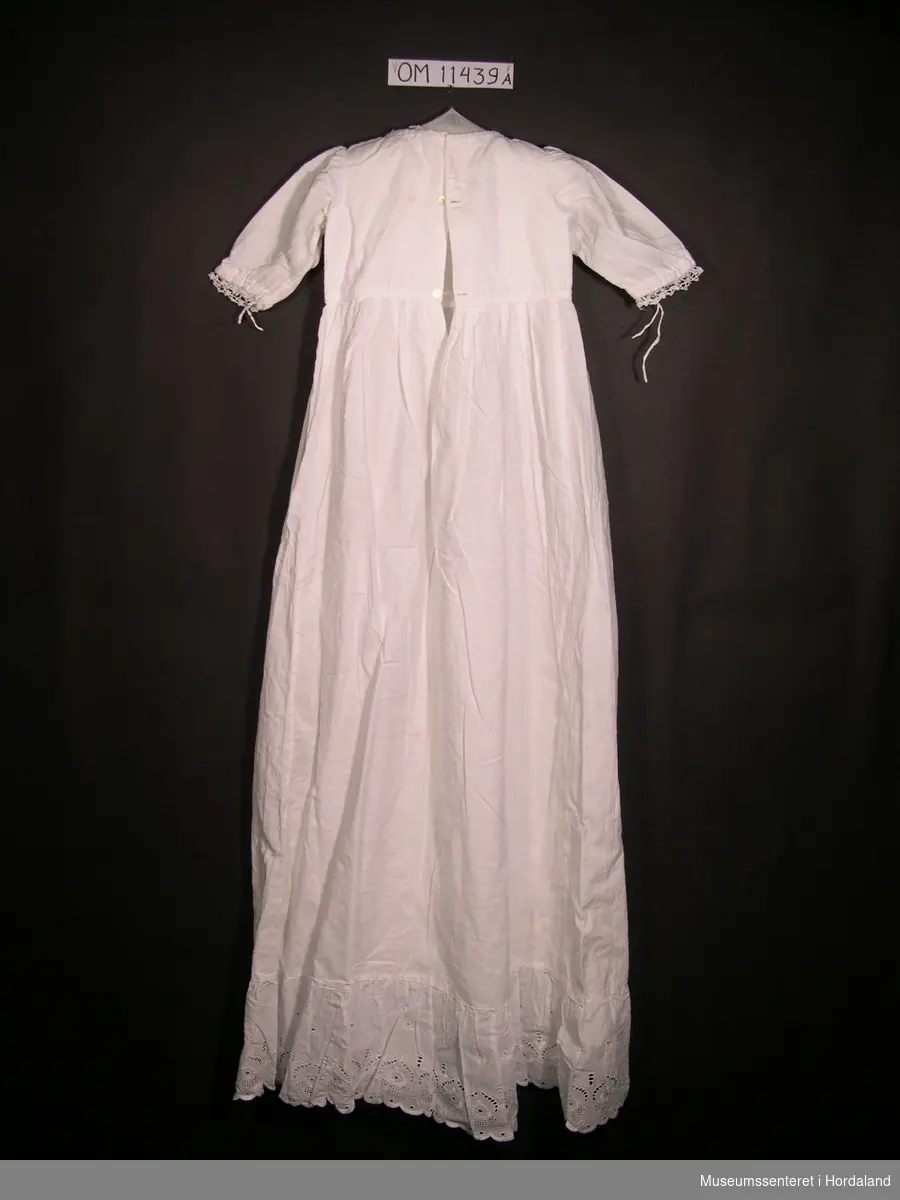 Form: lang dåpskjole med ermer, rund hals, underkjole, sjal og hekla krage

