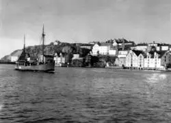 Bildet er fra havna i Kristiansund og viser M/S”Bjørnøy” M-84-A i fart inn Sørsundet.
Stålbåtens hoveddimensjoner er: L = 62 fot x B= 12,4 fot x D= 8 fot og byggeår er 1987 og utrustet med en BERGEN dieselmotor på 3300 hk, byggeår 1987. 
Eiere er Bernt Skarbøvik  A/S, Ålesund. I bakgrunnen ses Kirklandet med Jemar Norpowerbrygga bak fiskebåten. Info: Peter Storvik. - 
Båt i Sørsundet på vei inn til Kristiansund.
I bakgrunnen ser vi bryggene i Håla og Sørholmen på Kirkelandet.  Oppe til venstre ser vi noe av bebyggelsen  på Hålahaugen og sykehuset i Frueenget som var ferdig i 1899. 
I bakgrunnen ses Kirklandet med Jemar Norpowerbrygga bak fiskebåten
Nordmøre museums fotosamling