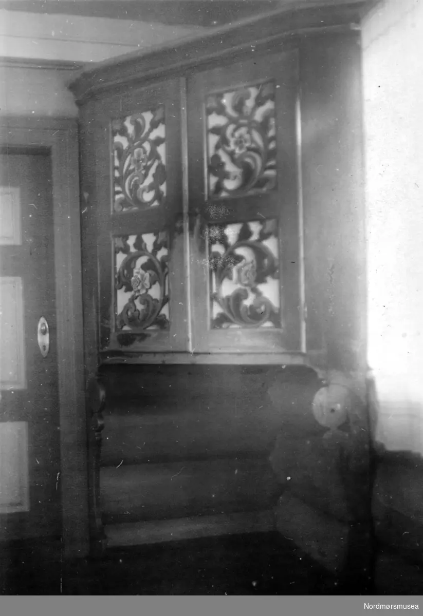 Dørparti fra Moøya i Surnadal kommune, hvor vi ser et skap lokalisert mellom to dørparti, hvorav det ene leder til gangen og det andre til kåven. Datering og fotograf er usikker, men fotograf er trolig Olaf Yderstad og
datering er sannsynligvis omkring 1954. Fra Nordmøre museums fotosamlinger.
