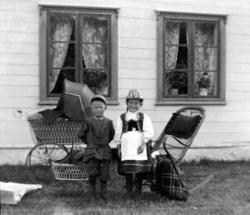 Foto av to Sverdrupbarn - en gutt og en jente - utenfor et b