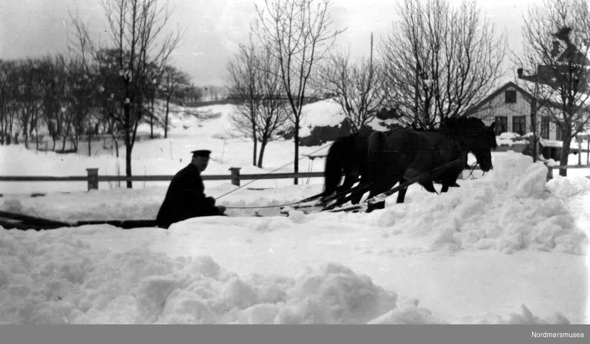 Et vinterbilde hvor vi ser en hest og slede langs landeveien en ukjent plass. Kan det være i Kristiansund? Er trolig fra en plass på Nordmøre eller i Romsdalen, Møre og Romsdal fylke. Datering er ukjent, men trolig omkring 1920 til 1939. Fra Nordmøre museums fotosamlinger.
