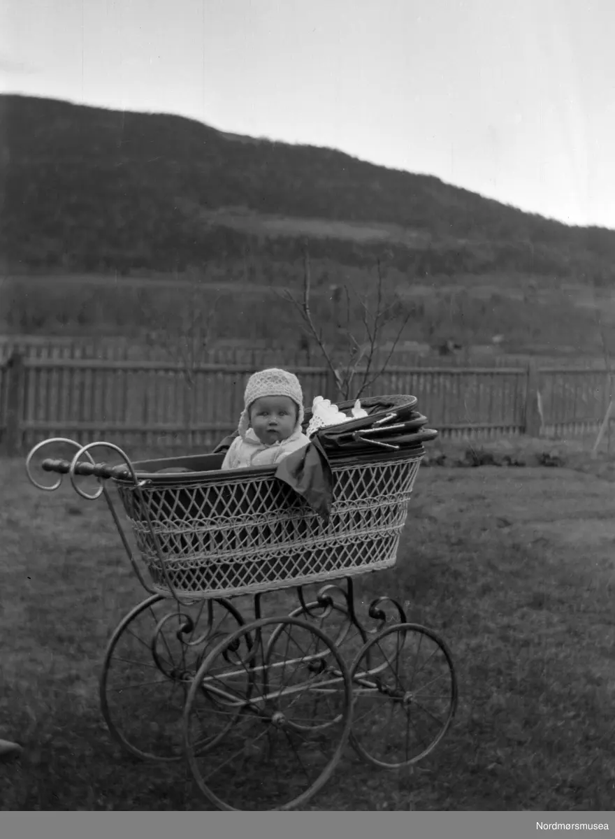 Foto av et lite barn i en barnevogn. Barnet er muligens fra Sverdrupfamilien/slekten, eventuelt fra deres bekjentskaper. Det er usikkert hvor bildet er tatt, men kan være fra Eidsvåg i Nesset kommune. Fra Nordmøre museums fotosamlinger. EFR2015