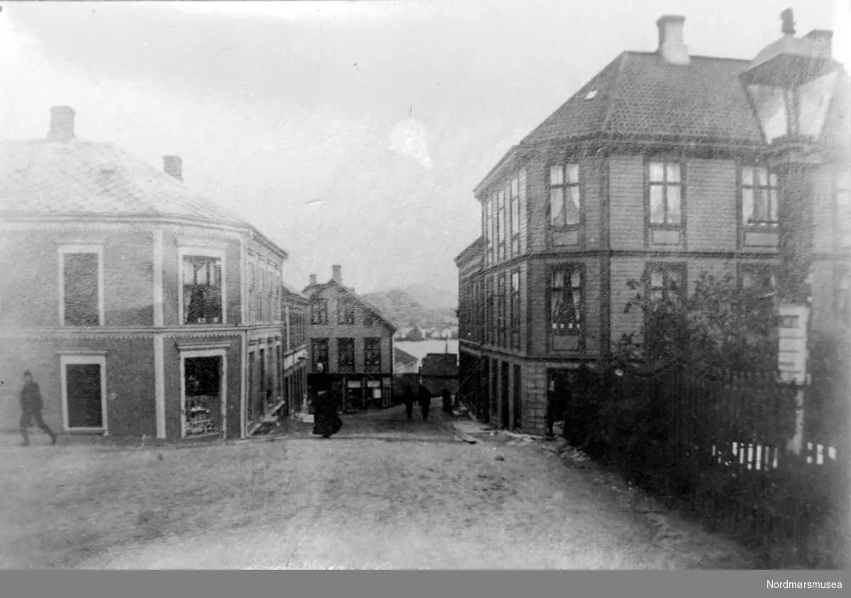 Postkort fra Torvet i Kristiansund.
 Gata i front går ned til Storgata.
 Havna sees i bagrunnen.(Fra Nordmøre Museums fotosamling)
