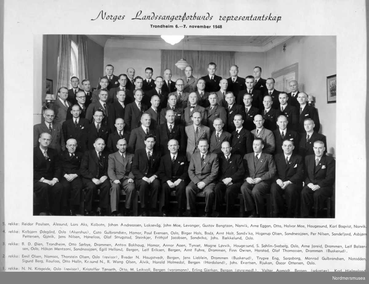 Norges landssangerforbunds representantskap. Trondheim 6. - 7. november 1948

1. rekke fra venstre: N. N. Krogeide, Oslo (revisor), Kristoffer Tønseth, Otta, M. Leikvoll, Bergen (varamann), Erling Gjerken, Bergen (styremedlem), Valter Aamodt, Bergen (sekretær), Karl Hjelmeland, Bergen (president), Anth. J. Nygård, Rosendal (visepresident), R. Keyser-Olsen, Haugesund (styremedlem), Andr. Lønnebotten, Bergen (styremedlem), Petro Johannessen, Bergen (varamann) og Hermod Rasmussen, Molde.

2. rekke fra venstre: Emil Olsen, Namsos, Thorstein Olsen, Oslo (revisor), Breder N. Haugstvedt, Bergen, Jens Lieblein, Drammen (Buskerud), Trygve Eng, Sarpsborg, Monrad Gulbrandsen, Notodden, Sigurd Berg, Raufoss, Otto Halln, Kr.sund N., R. Wang Olsen, Ålvik, Harald Holmedal, Bergen (Hordaland), Johs. Evertsen, Rjukan, Oscar Ottersen, Oslo.

3. rekke fra venstre: B. D. Øien, Trondheim, Otto Sørbye, Drammen, Anton Bakhaug, Hamar, Annar Aaen, Tynset, Magne Løvik, Haugesund, S. Sahlin-Sveberg, Oslo, Arne Jareid, Drammen, Leif Balzersen, Oslo, Håkon Mentzoni, Sandnessjøen, Egill Helland, Bergen, Leif Eriksen, Bergen, Arnt Fuhre, Drammen, Finn Owren, Harstad og Olaf Thomassen, Drammen (Buskerud).

4. rekke fra venstre: Kolbjørn Ødegård, Oslo (Akershus), Cato Gulbrandsen, Hamar, Paul Evensen, Oslo, Birger Hals, Bodø, Arnt Holt, Sandvika, Hagerup Olsen, Sandnessjøen, Per Nilsen, Sandefjord, Asbjørn Pettersen, Gjøvik, Jens Nilsen, Hønefoss, Olaf Strugstad, Steinkjær, Frithjof Jacobsen, Sandvika og Johs. Bækkelund, Oslo.

5. rekke fra venstre: Reidar Paulsen, Ålesund, Lars Aks, Kolbotn, Johan Andreassen, Laksevåg, John Moe, Levanger, Gustav Bengtzon, Narvik, Arne Eggan, Otta, Halvor Moe, Haugesund og Karl Boquist, Narvik.

Fra Mannskoret ";Varde"; sine arkiver. Se også reg. nr. KMb-2009-009.0016. Fra Nordmøre Museum sin fotosamling.



