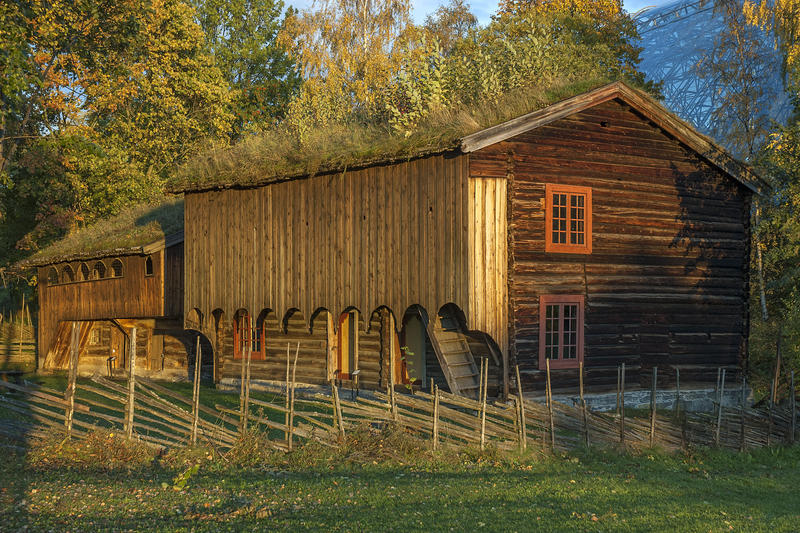 Grimsrudbygningen på Hedmarkstunet er en brunlig toetasjers tømmerbygning med to rutete vinduer over hverandre i gavleveggen og tettet svalgang i andre etasje. (Foto/Photo)