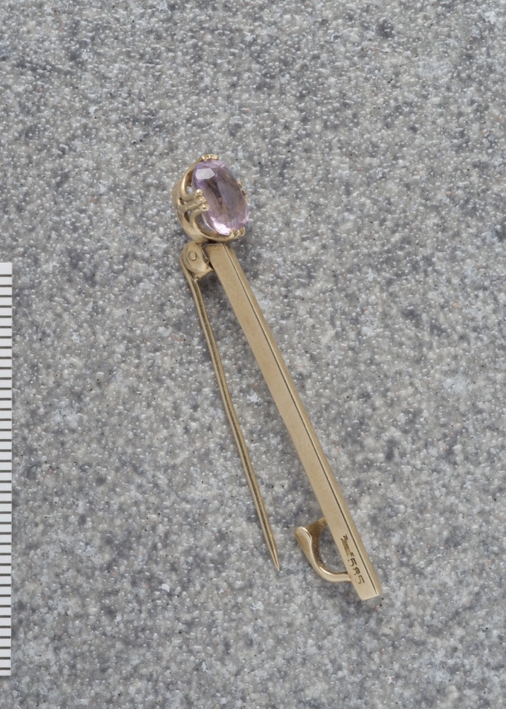 Slipsnål (antatt) i gull med en lys lilla smykkestein, antatt ametyst.
