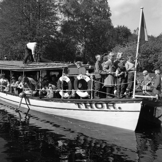 Foto av flera turister på ångbåt utflykt. Ångbåt heter