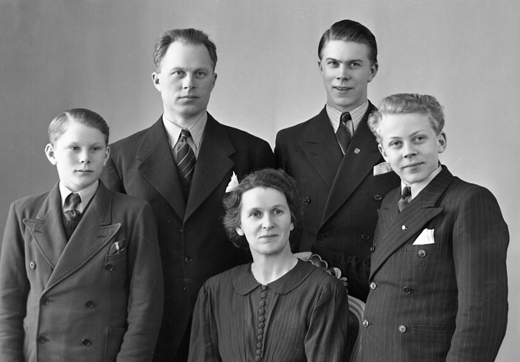 Foto av en familj med tre pojkar i varierande ålder.
Midjebild.  Ateljéfoto.
Trol. Arvid Persson (1898-1989), Alvesta. Gift 1921 med Greta Ottilia Elisabet (1903-1988).
Källa: Bl a Sveriges Dödbok 1901-2009.