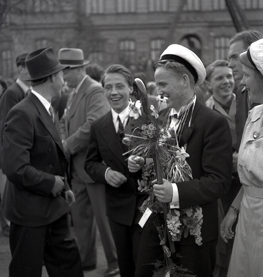 De första studenterna. 1944.
Några studenter gratuleras med käpp och blommor m.m.