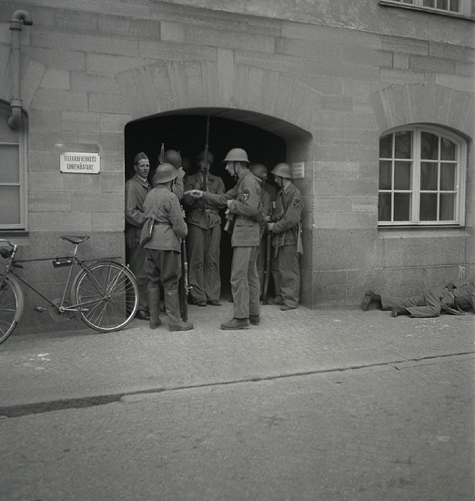 Hemvärnet, 1942. 
Några män i hemvärnsuniform har samlats vid källaringången till
dåv. Post- och Riksbankshuset.