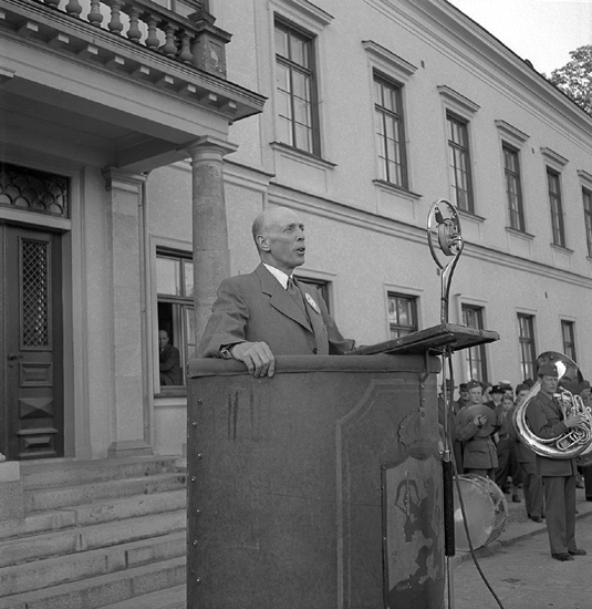 Barnens Dag, 31/5 1946. 
En okänd man i kostym talar från en talarstol utanför Residenset i Växjö. 
I bakgrunden skymtar man Kronobergs regementes musikkår m.m.