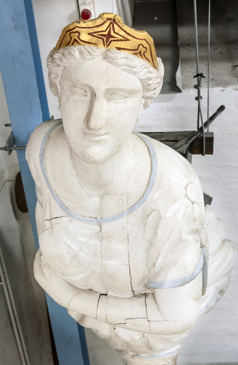 Galjonsbild, av trä. Skulptur föreställande en kvinnofigur /helfigur/ med ena handen horisontellt hållen under bröstet; den andra håller hop klädningen vid höger sida. Dräkten är av empirekaraktär /tunika/ med två knappar på vardera överarm. Håret har stor knut i nacken. Hela kvinnofiguren är vit, med blå kanter på dräkten. Framtill på huvudet ett diadem, målat i guld och rött. Den bevarade delen av fartygsbogen är svart- och rödmålad. Kvinnofiguren vilar på båda sidorna undertill på en smal slinga, vit med röda orneringar. 
Acc. kat: Galijonsbild, kvinnofigur, trä (pitch-pine), från fartyget "Cuthona" från Raumo, Finland. Förlist å Bredbädan SV om Simpnäsklubbs fyr den 15/11 1897 kl. 00.45. Var på resa från Sundsvall till Melbourne med trä.  Sedan 1897 uppställd i en trädgård, Upplandsbodarna.