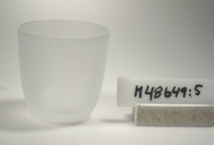 Dricksglas/selterglas. "UD"
Något rundad, cylindrisk form.
Hela ytan blästrad.

Gåva av bruket år 1997-05-14.
Funktion: Dricksglas/selterglas