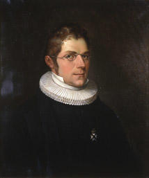Portrett av Nicolai Wergeland. Kort hår, briller, presteklole og prestekrave. En orden.