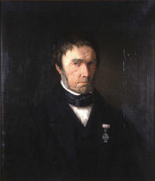 Portrett av Zacharias Mellebye. Mørk drakt, svart halsbind, hvit skjorte. Orden festet på jakkeslaget.