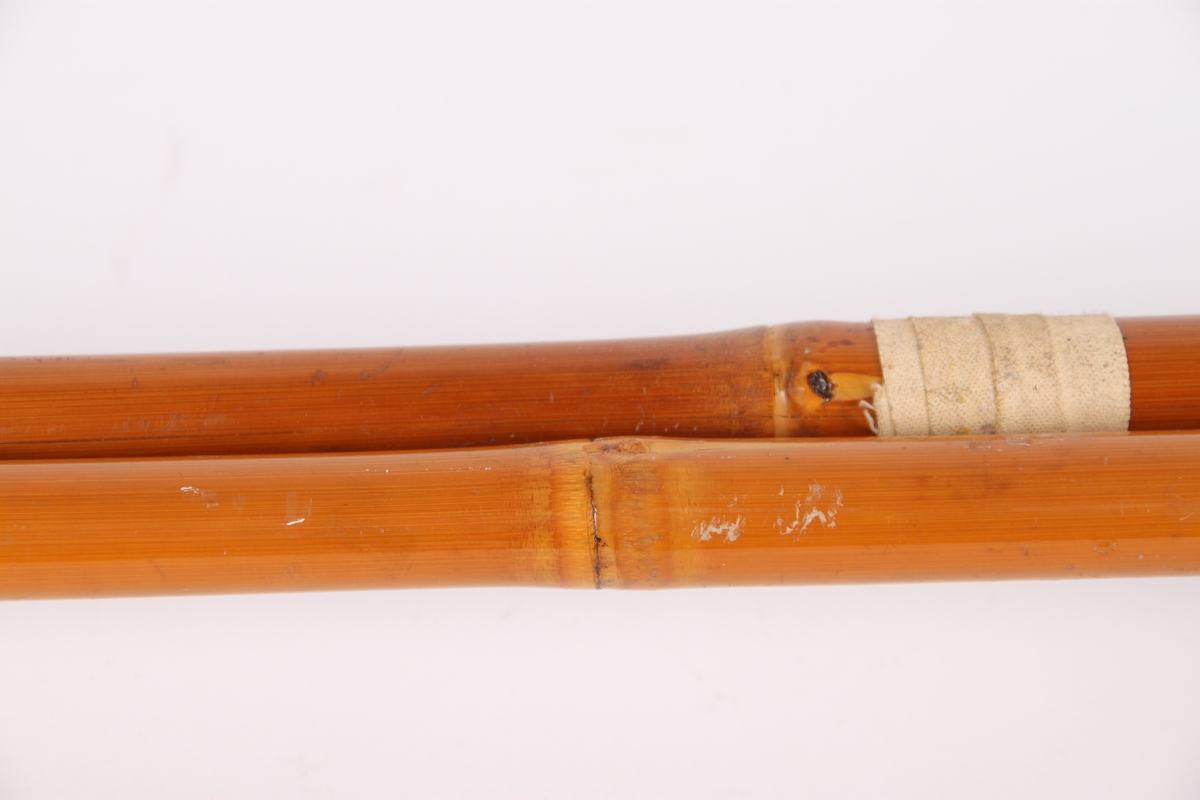 Skistaver i bambus med trinse og sydde lærhåndtak. Den ene staven er reparert og forsterket med tape i løpet av brukstiden.