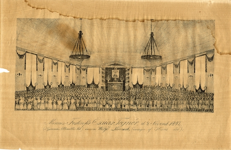 Litografi, efter teckning. 
Minnesfest över Esaias Tegnér, hållen på årsdagen av hans död, 2 november 1847 i dåvarande Läroverkets festsal i Växjö (numera Norrtullskolan).