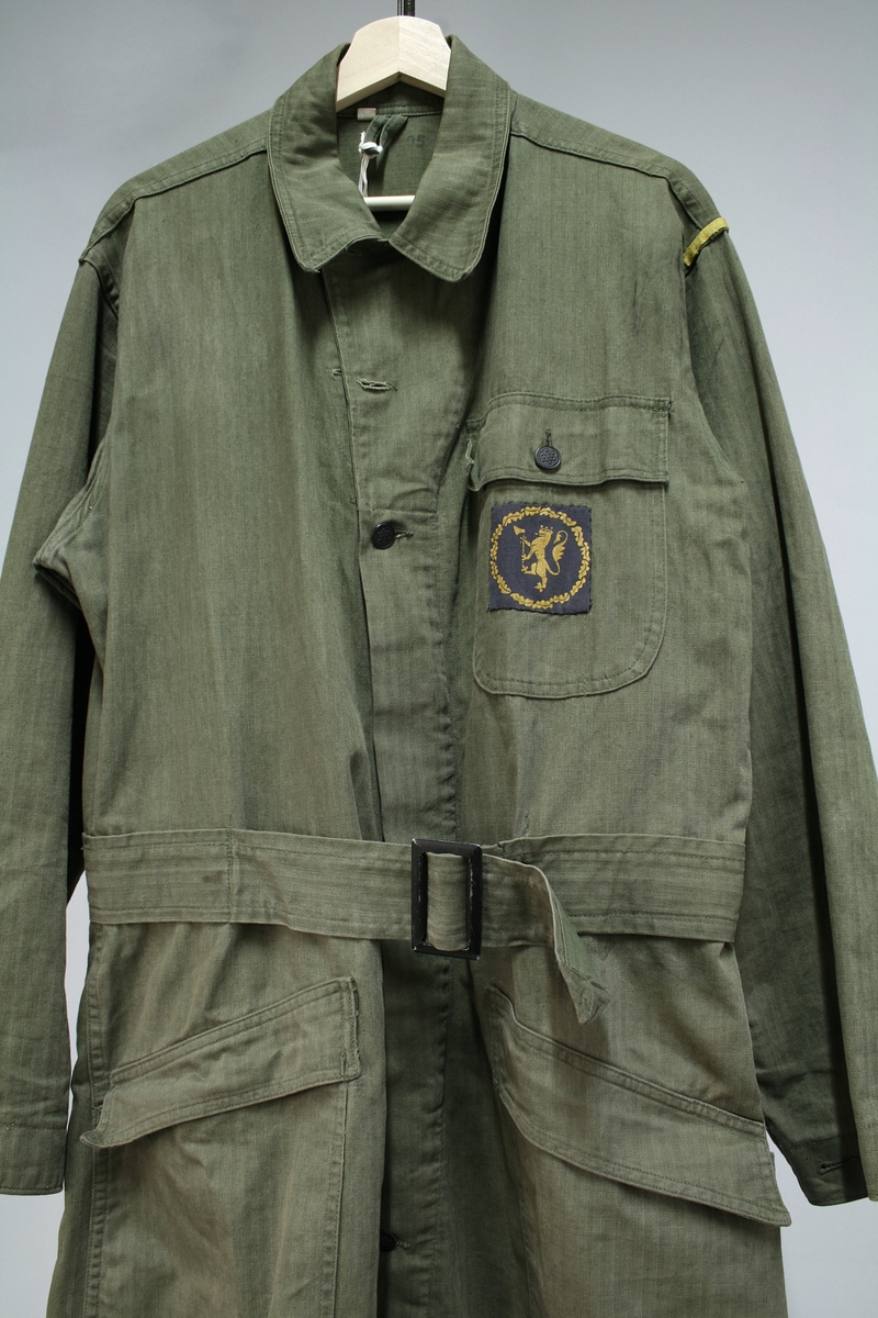 Militærgrønn kjeledress/overall med politimerking på brystet. Knappene tyder på at dressen er produsert i USA.