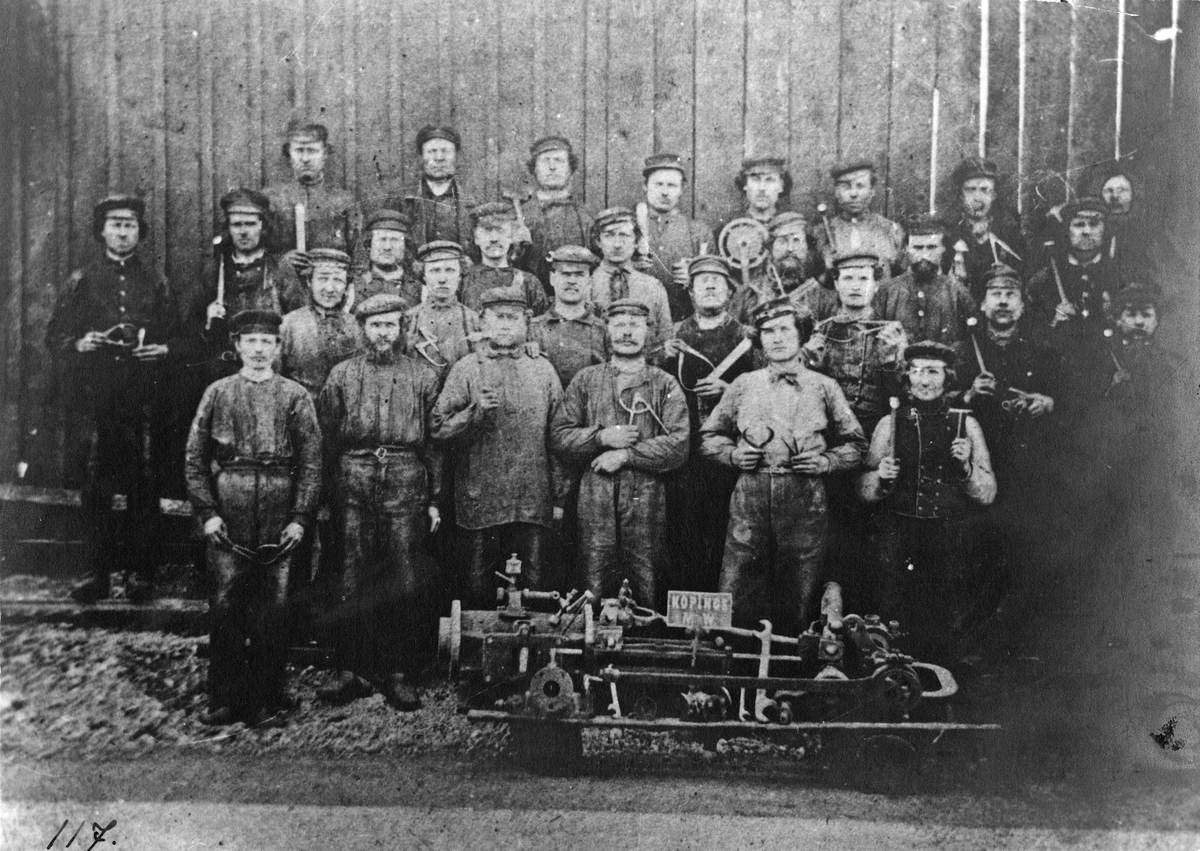 Grupp av arbetare vid KMV. Förstorad reproduktion av foto från 1860-talet. Verkstaden anlades 1857.