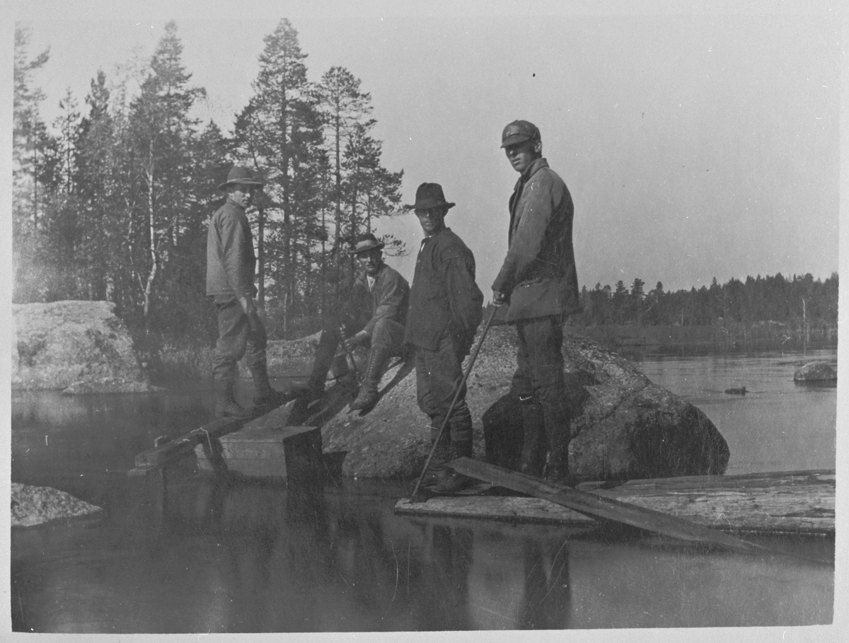 En grupp män som arbetar vid en sjö.