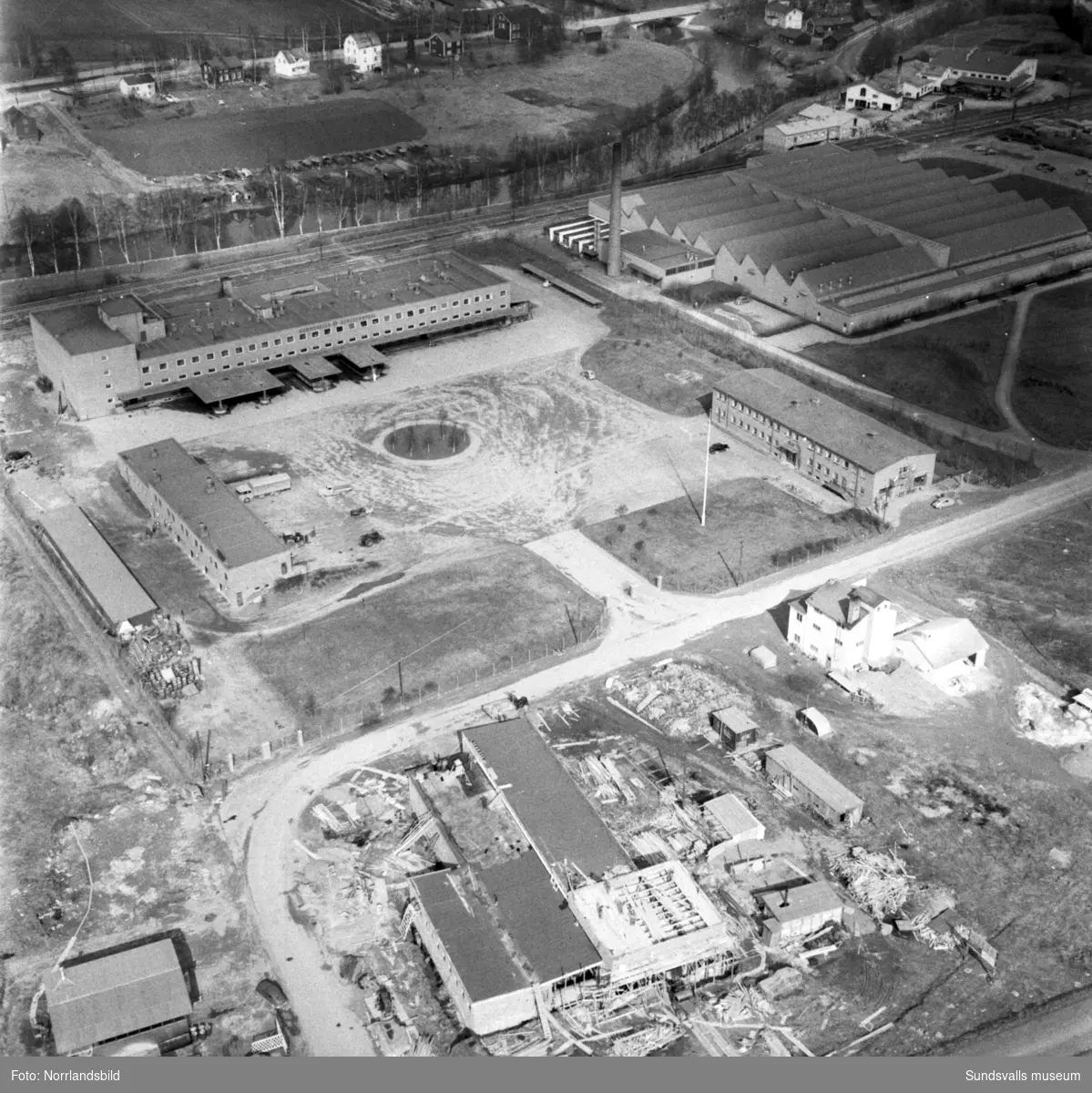 Flygfoto över Nacksta industriområde med Mjölkcentralen, Televerkstaden samt pågående bygge av Cocacola-fabrikens industrifastighet.