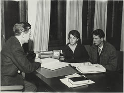 Mann og kvinne i samtale med annen mann på et kontor.