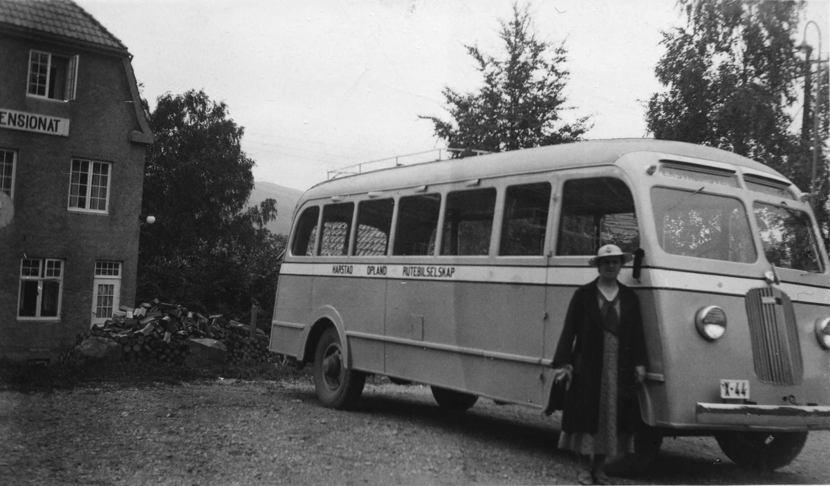 Guri Nygaard foran HORBs buss X-44. Pensjonat i bakgrunnen.