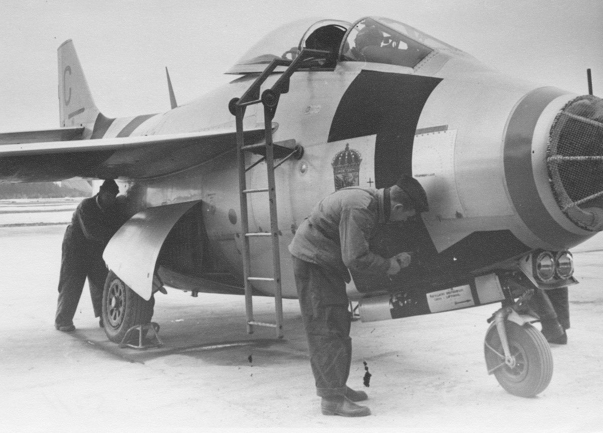 Mekaniker arbetar med flygplan 29 Tunnan på ett flygfält under flygvapenövningen 1956 (FVÖ-56).