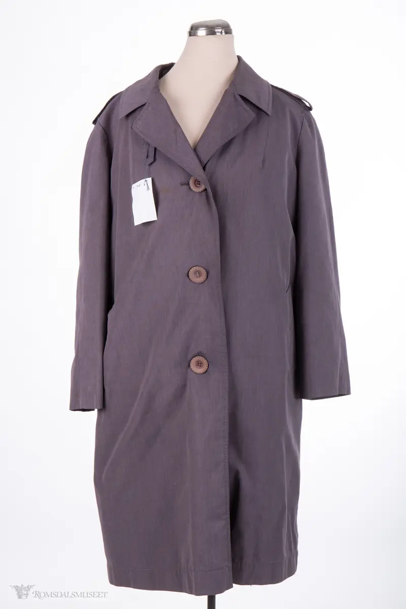 Rettskåret, moderat lengde, enkeltspent med 3 knapper, nedbrettet krage og slag, 2 sidelommer med klaff,uten lukning. Helforet med nylonstoff,påkneppbart teddyfor.