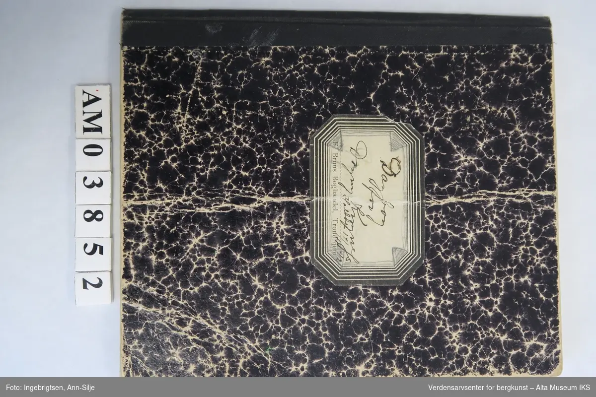 En notatbok med håndskrevet beretning, i tillegg til en oversikt over innkjøp. Lenger bak i notatboka ser det ut til at den også er brukt til matteoppgaver. Den er skrevet i med både sort penn og blyant.