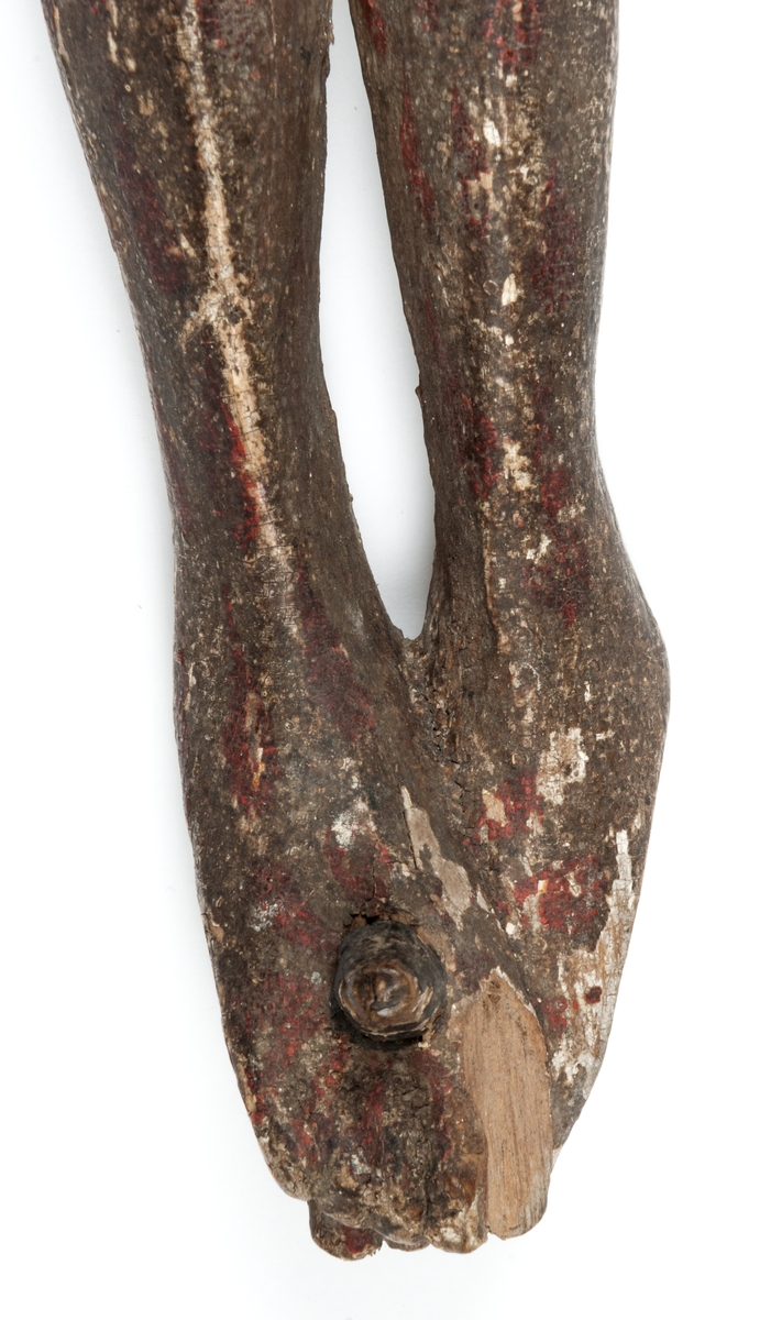 Krucifix, s.k. processionskrucifix, från 1400-talets början? Figuren synes ha varit förgylld, bloddroppar målade över hela kroppen. Kring höfterna ländkläde; törnkrona som verkar rullad duk el. dyl. Tvådelat skägg, hår och skägg svarta. Ena foten skadad. Själva korset saknas.