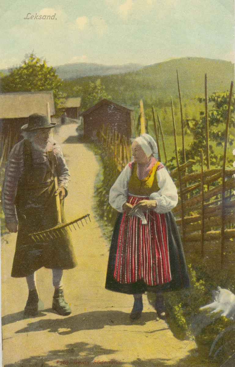 Vykort med man och kvinna iförda folkdräkter från Leksand.