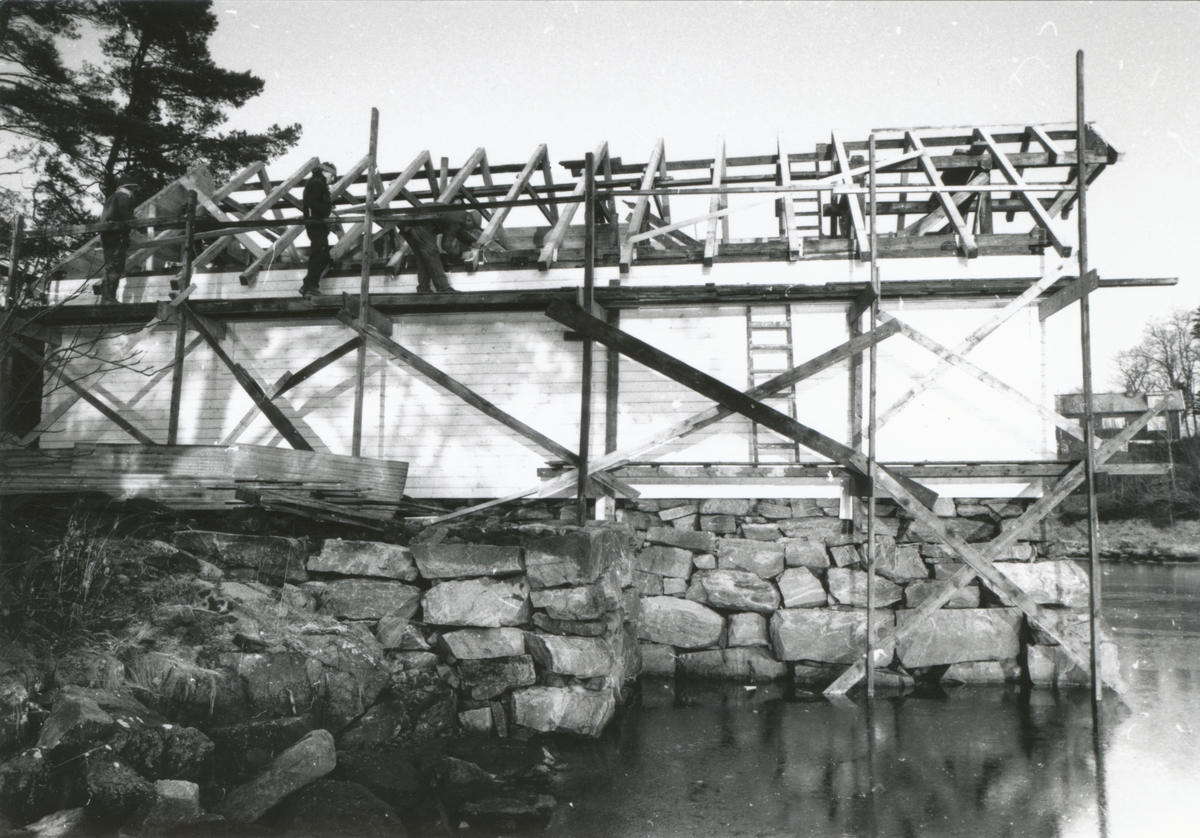 Bildeserie av gjenoppføringa av Larsnesbua, også kallt Seljeset-buda på Sunnmøre Museum, februar 1992. Einar Fagerli er arbeidsleiar for arbeidet, og det er gjennom "Arbeid for trygd"- ordninga ein har fått folk til arbeidet.
