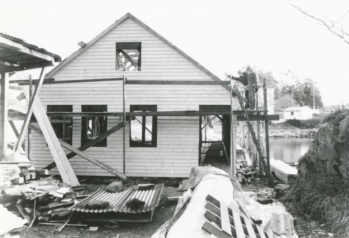 Bildeserie av gjenoppføringa av Larsnesbua, også kallt Seljeset-buda på Sunnmøre Museum, februar 1992. Einar Fagerli er arbeidsleiar for arbeidet, og det er gjennom "Arbeid for trygd"- ordninga ein har fått folk til arbeidet.