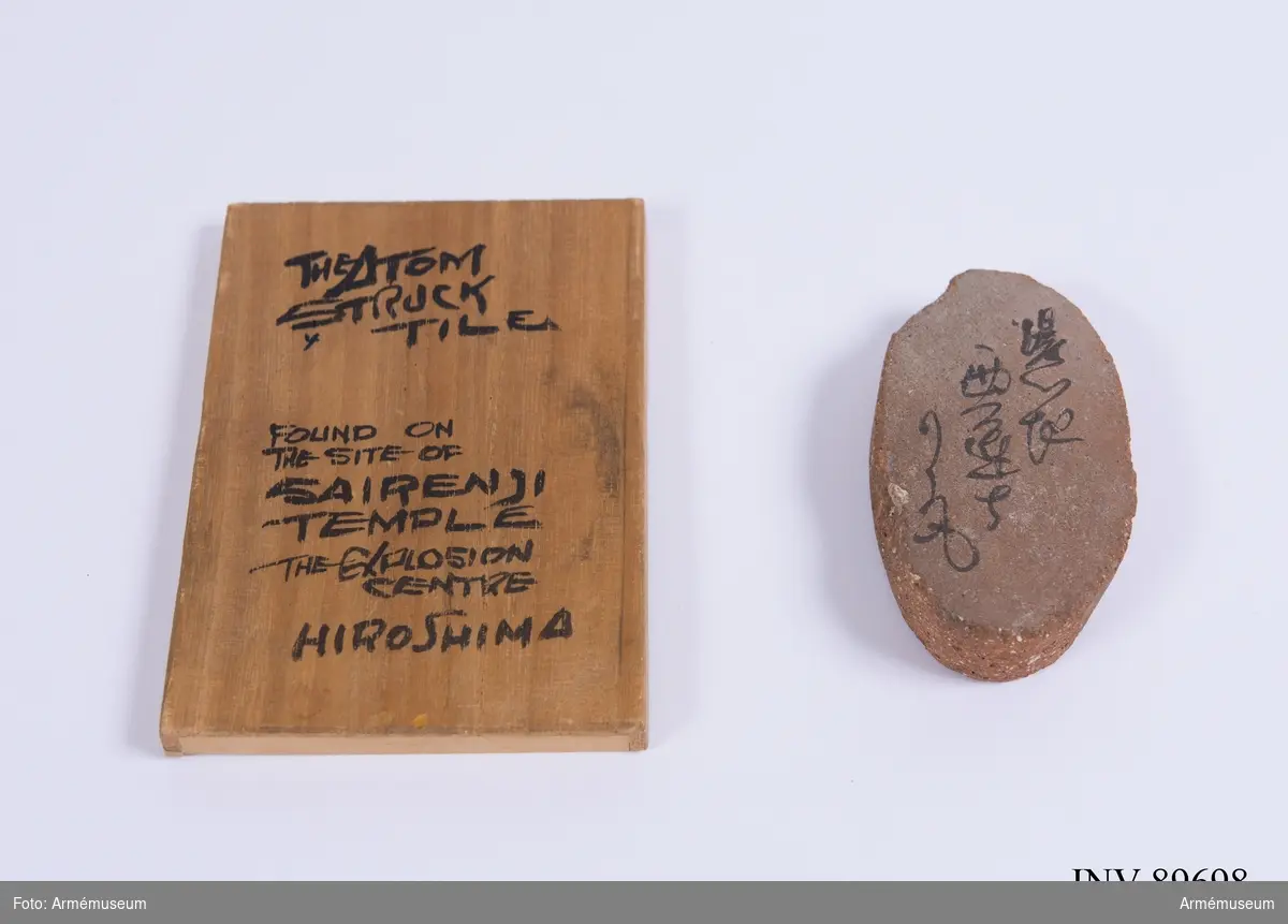 Takpanna från Sairenjitemplet i Hiroshima med tillhörande trälock och inskriptioner. Föremålet är tillägnat Stig Frick-Meijer, då verksam inom Röda korset.
