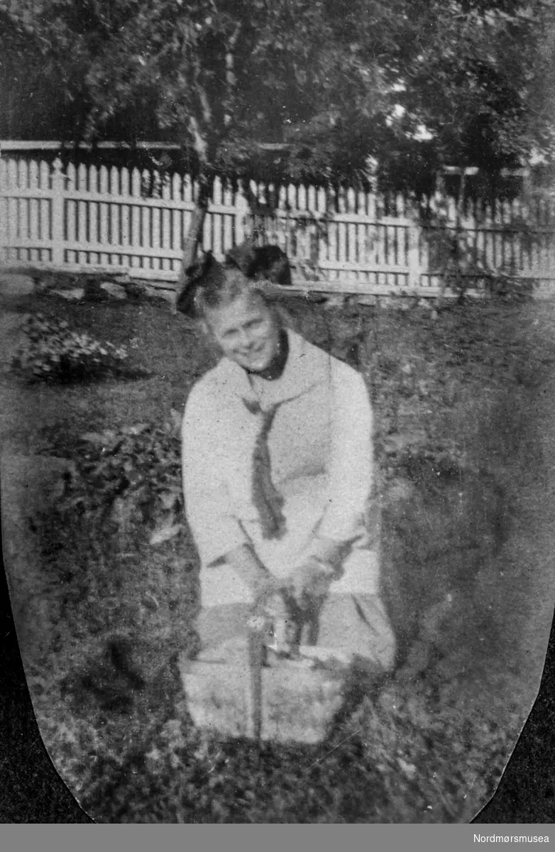 "Gudrun(?) i haven" Fra et fotoalbum tilhørende Ellinor Williams-Phakdikun (1905-1963). Kan være fra Kragerø. Fra Nordmøre museums fotosamlinger.