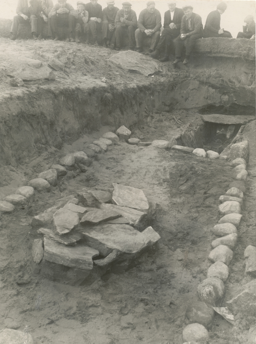 Utgravinga av ei barnegrav på Blimshaugen på Vigra. Grava var dekt av et grovt dekke med et gjerde rundt. I bakgrunnen viser den opne mannssgrava og utgraverene.