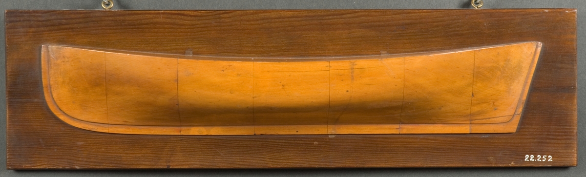 Halvmodell av Kvasikanot (kanot). Kravellbyggd, rak stäv och spetsgattad. Monterad på fernissad platta.