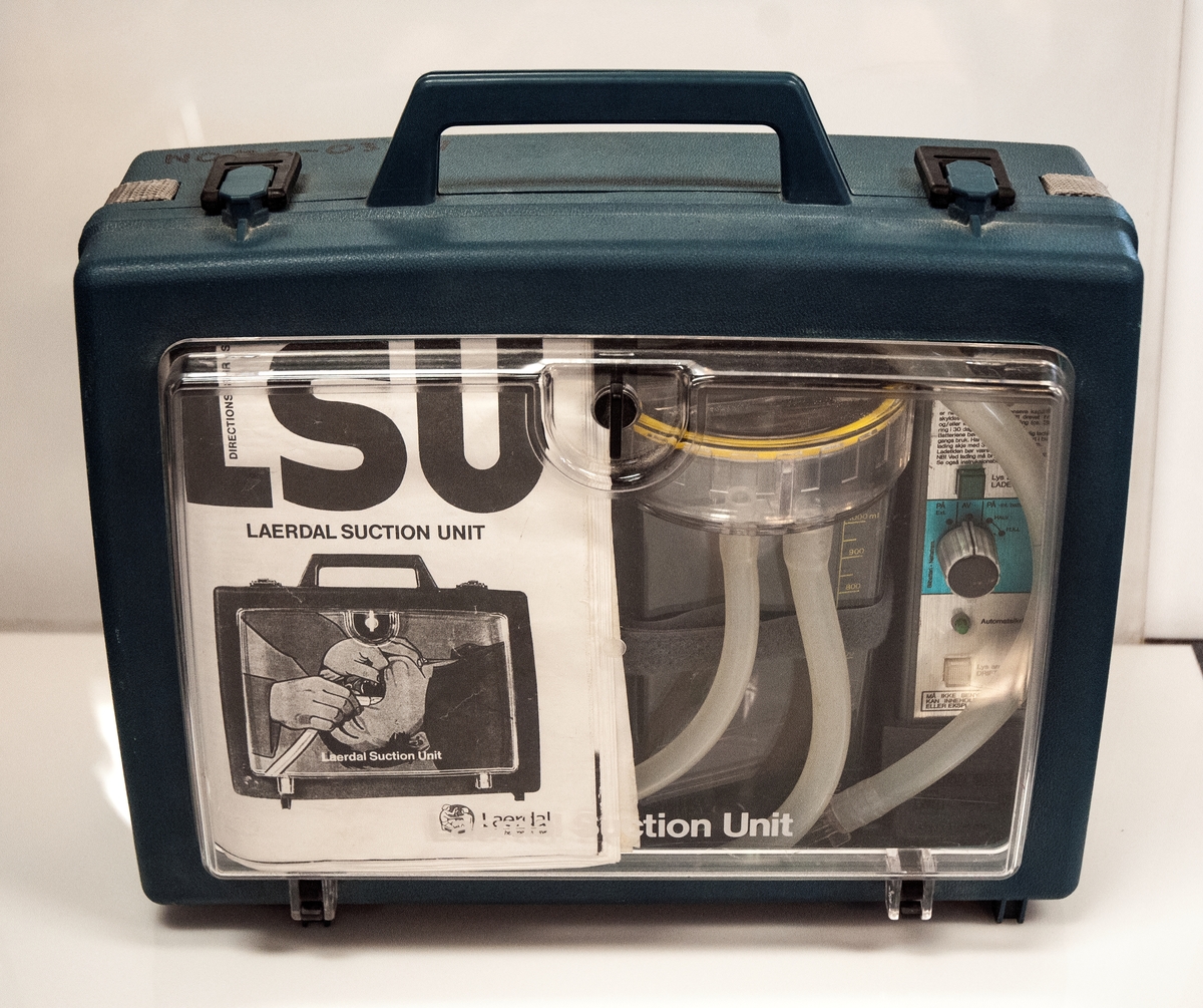 Puste- sugeapparat, populært kalt Lærdal Sug. Brukes til å suge slim ut av luftvegene for å opprettholde pustefunksjonen. Drives av ladbart batteri. Oppbevares i dertil egnet koffert. Bruksanvisning medfølger.