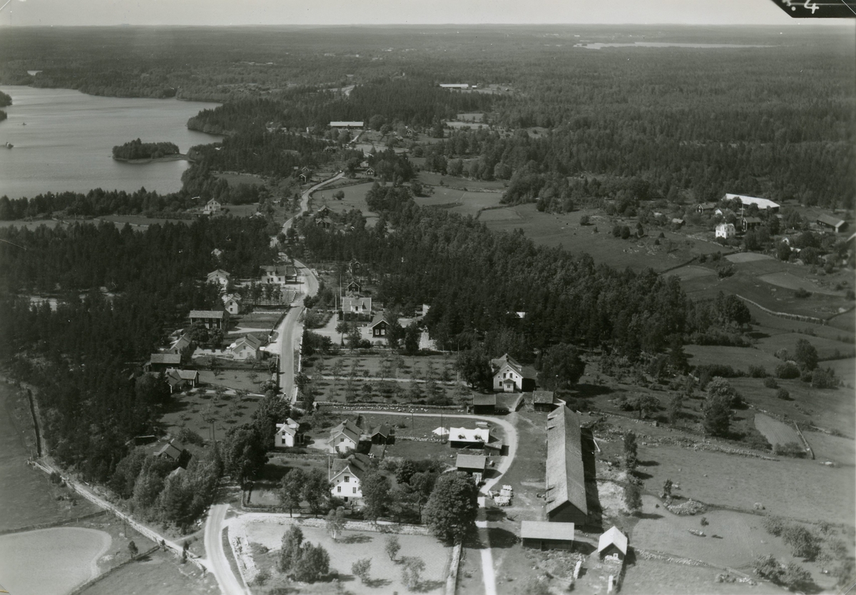 Flygfoto över Björnhult. Samhället med bondgård och bygatan samt hus.